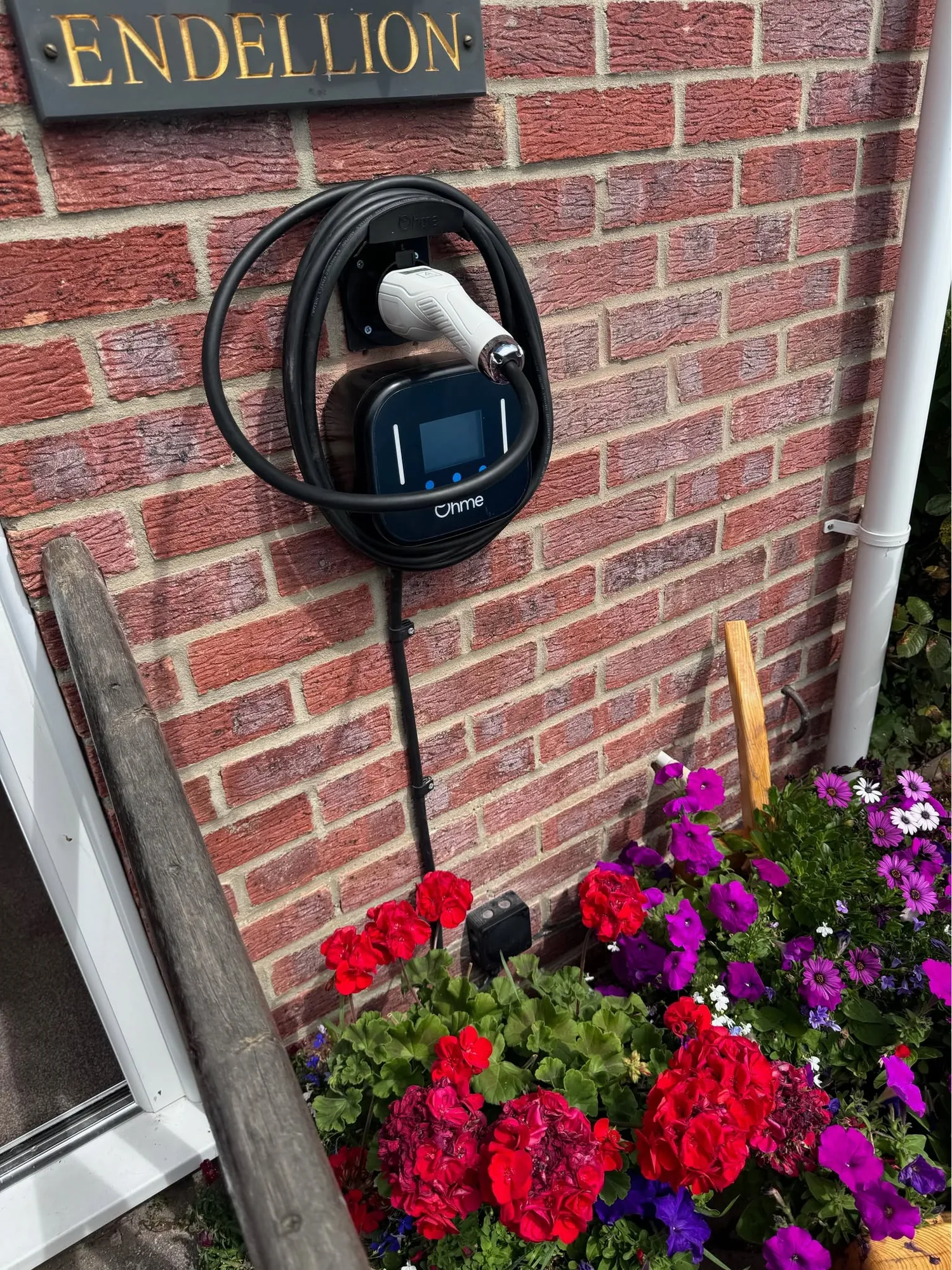Ohme home EV charger installed on a brick wall in Worthing